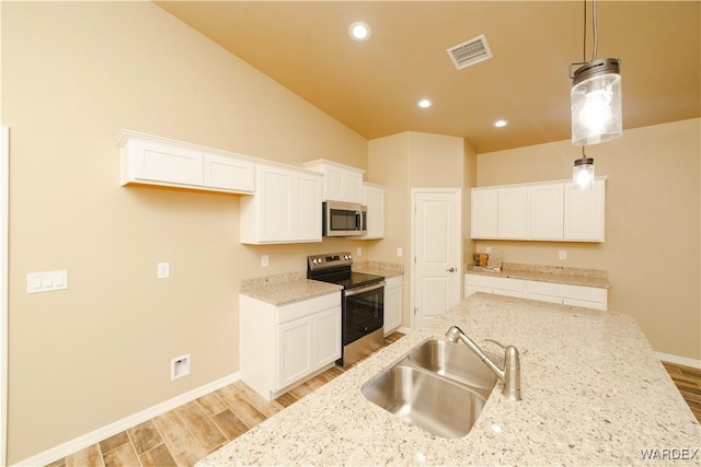 kitchen featuring stainless steel appliances, light wood finished floors, a sink, and visible vents