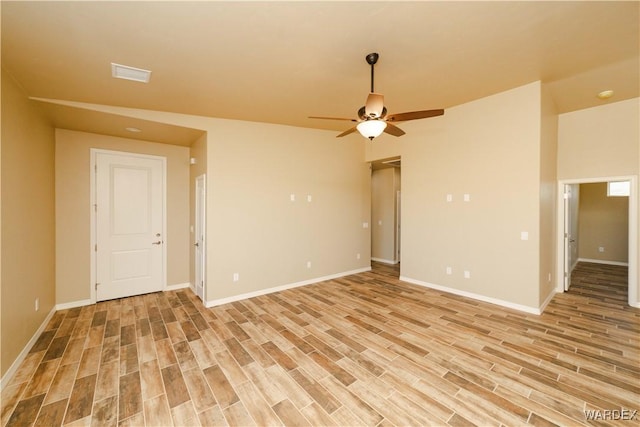 empty room with visible vents, baseboards, a ceiling fan, and light wood-style floors