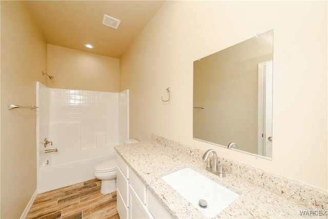 full bathroom featuring visible vents, toilet, wood tiled floor, bathtub / shower combination, and vanity