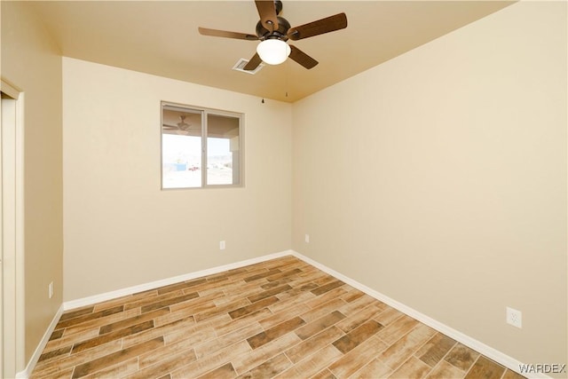 empty room featuring light wood-type flooring, visible vents, ceiling fan, and baseboards