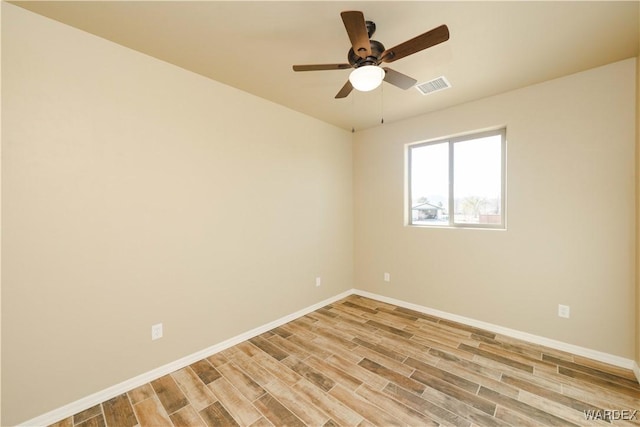 unfurnished room featuring light wood finished floors, a ceiling fan, visible vents, and baseboards