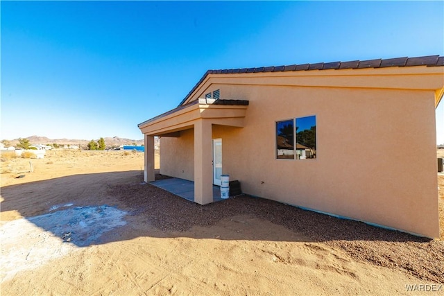 view of side of home with a patio area and stucco siding