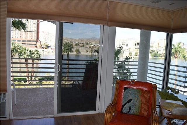 doorway to outside with a water view and wood finished floors