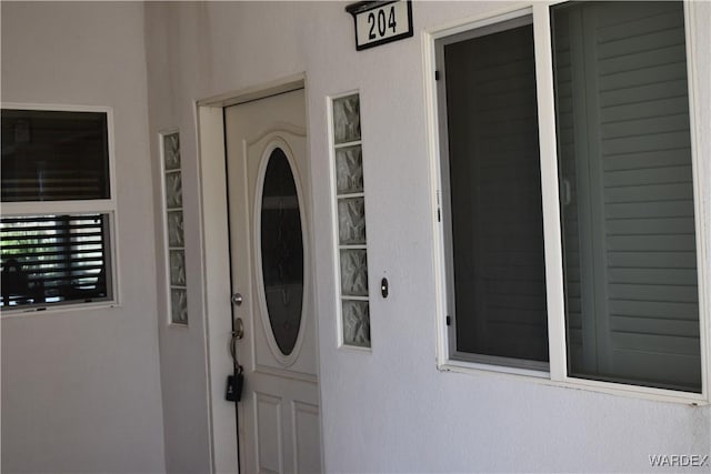 view of exterior entry featuring stucco siding