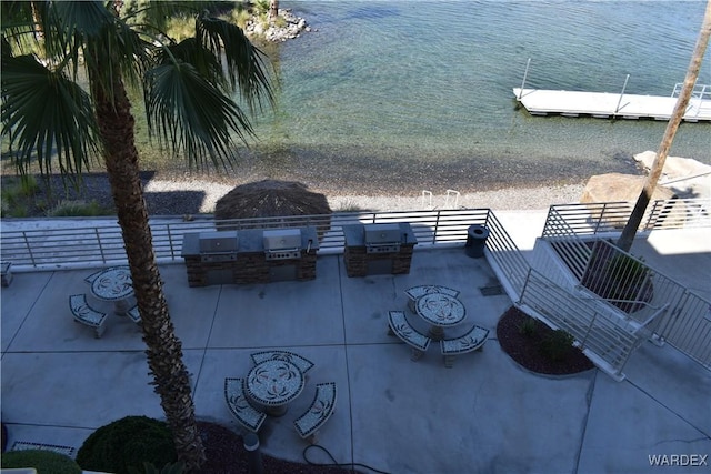 view of patio featuring exterior kitchen and a water view