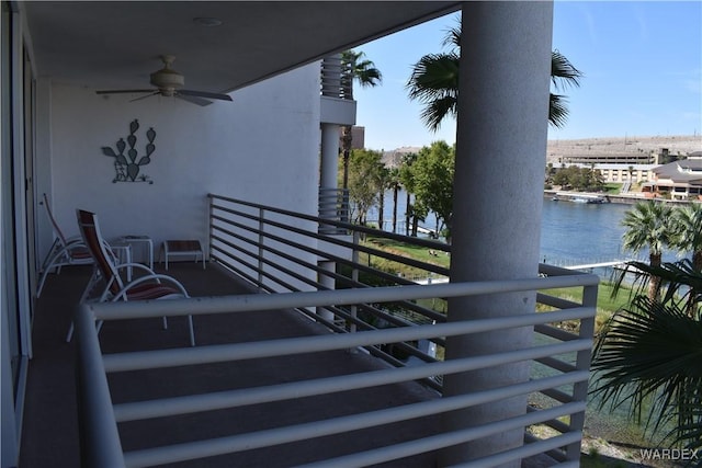 balcony featuring a water view and a ceiling fan