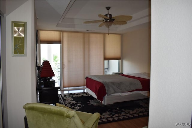 bedroom featuring a tray ceiling and wood finished floors