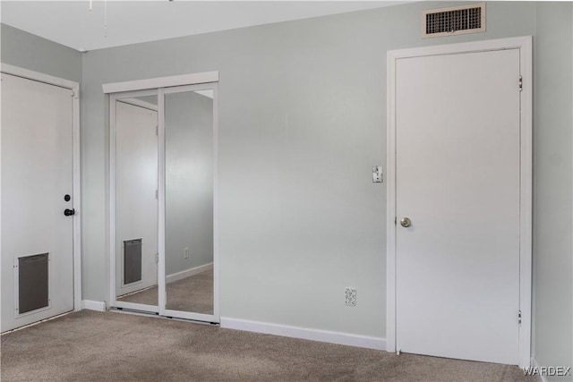 unfurnished bedroom featuring carpet floors, baseboards, and visible vents