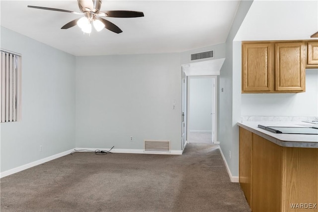 interior space featuring baseboards, visible vents, ceiling fan, and carpet flooring