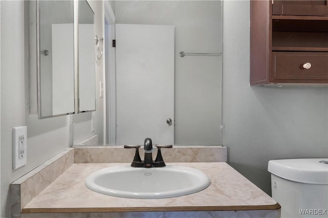 half bath featuring vanity and toilet