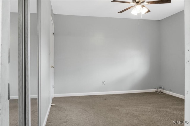 spare room with ceiling fan, carpet, and baseboards