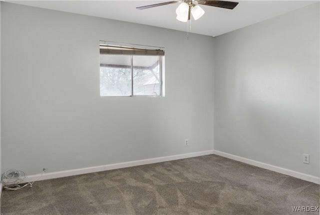 carpeted spare room featuring ceiling fan and baseboards