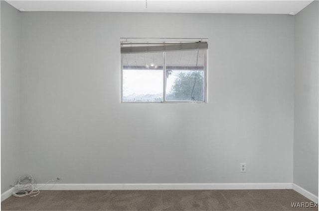 unfurnished room featuring carpet flooring and baseboards