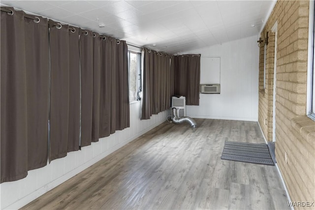 spare room with lofted ceiling, light wood-style flooring, and cooling unit