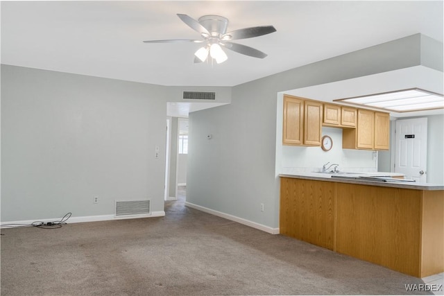 kitchen featuring light carpet, light countertops, and visible vents