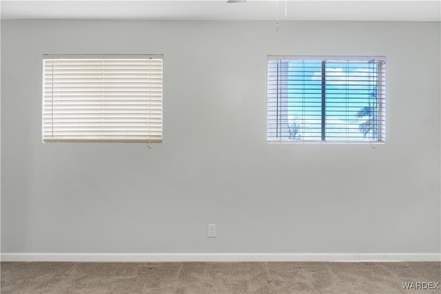 carpeted spare room featuring baseboards