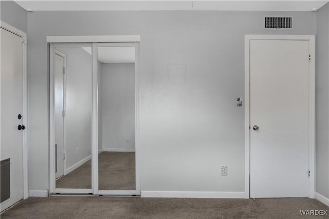 unfurnished bedroom with carpet, visible vents, and baseboards