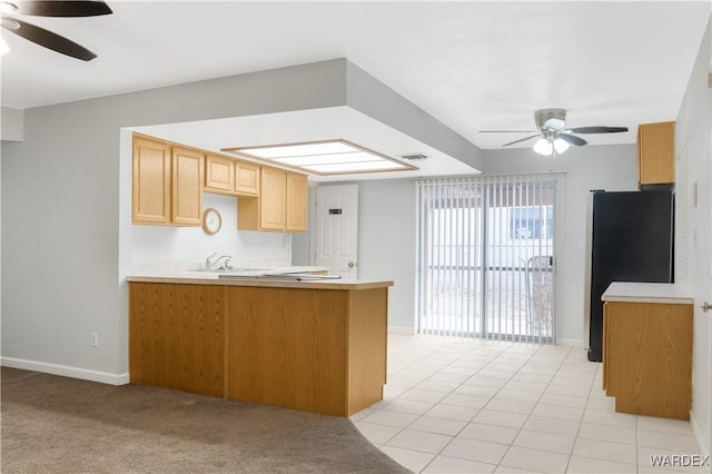 kitchen with ceiling fan, a peninsula, light countertops, and freestanding refrigerator