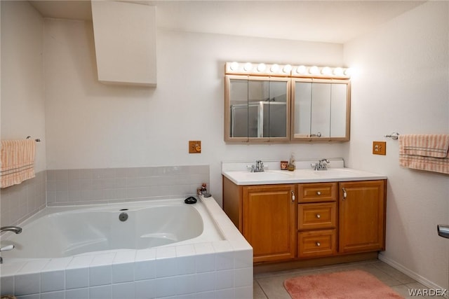 bathroom with a garden tub, double vanity, tile patterned flooring, and a sink