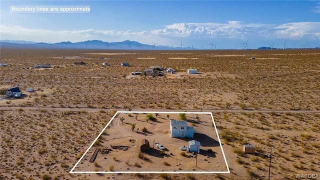 birds eye view of property featuring a mountain view and view of desert
