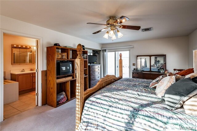 bedroom featuring access to exterior, visible vents, light carpet, a sink, and ensuite bath