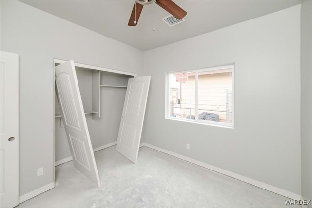 unfurnished bedroom with a closet, unfinished concrete flooring, visible vents, and baseboards