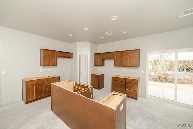 kitchen featuring brown cabinets, a center island, and visible vents