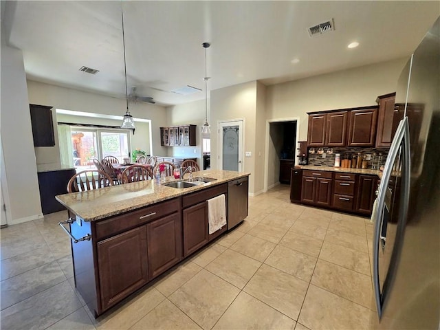 4132 Monte Silvano Ct, Kingman, AZ 86401 - kitchen with freestanding refrigerator, dishwashing machine, ceiling fan, dark brown cabinets, and decorative light fixtures