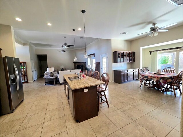 4132 Monte Silvano Ct, Kingman, AZ 86401 - kitchen with stainless steel refrigerator with ice dispenser, a ceiling fan, ornamental molding, dark brown cabinetry, and an island with sink