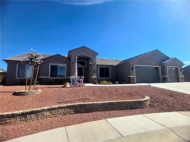 4132 Monte Silvano Ct, Kingman, AZ 86401 - single story home featuring an attached garage, stone siding, stucco siding, and driveway