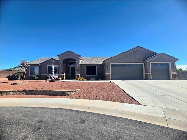 4132 Monte Silvano Ct, Kingman, AZ 86401 - ranch-style house with a garage, stone siding, driveway, stucco siding, and a tile roof