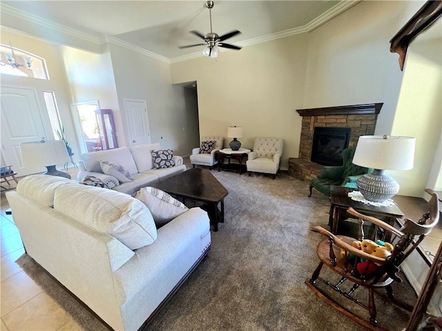 4132 Monte Silvano Ct, Kingman, AZ 86401 - living area featuring crown molding, a stone fireplace, a ceiling fan, and tile patterned flooring