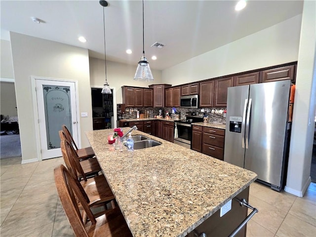 4132 Monte Silvano Ct, Kingman, AZ 86401 - kitchen featuring stainless steel appliances, dark brown cabinets, a kitchen breakfast bar, a spacious island, and tasteful backsplash