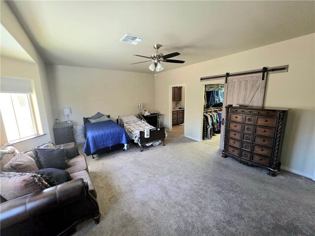 4132 Monte Silvano Ct, Kingman, AZ 86401 - carpeted bedroom with a barn door, a spacious closet, a ceiling fan, and a closet
