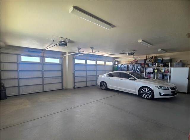 4132 Monte Silvano Ct, Kingman, AZ 86401 - garage featuring a garage door opener and freestanding refrigerator