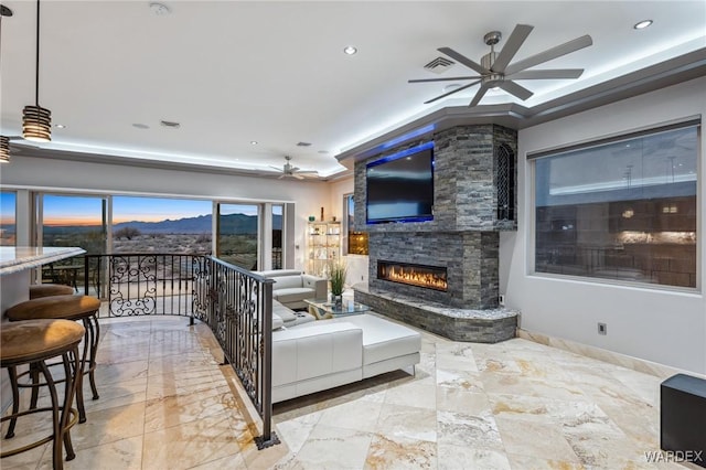 living area with visible vents, a glass covered fireplace, recessed lighting, baseboards, and ceiling fan