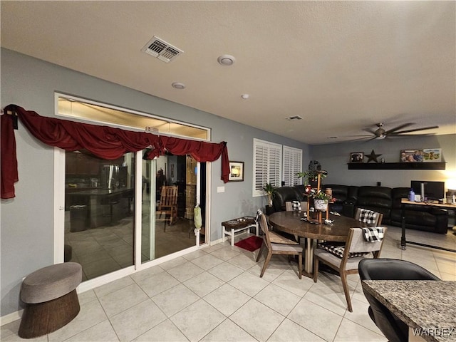 dining area with a ceiling fan, visible vents, baseboards, and light tile patterned floors