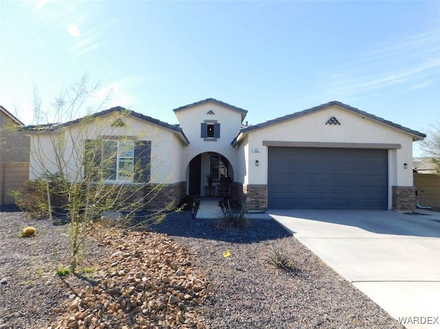 view of front of home featuring a garage, stone siding, driveway, and stucco siding