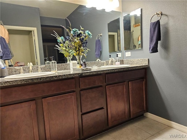 bathroom with double vanity, a sink, and tile patterned floors