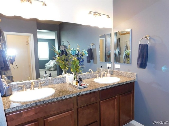 full bathroom with double vanity and a sink