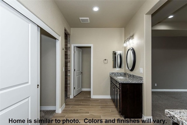 full bathroom with wood finish floors, recessed lighting, visible vents, vanity, and baseboards