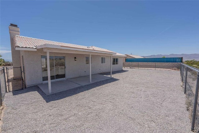 1925 E Ln Entrada Pl, Fort Mohave, AZ 86426 - rear view of house featuring a fenced backyard, stucco siding, a chimney, a tile roof, and a patio
