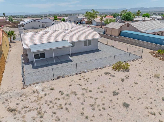 1925 E Ln Entrada Pl, Fort Mohave, AZ 86426 - rear view of property with a residential view, a tile roof, a patio area, a fenced backyard, and stucco siding
