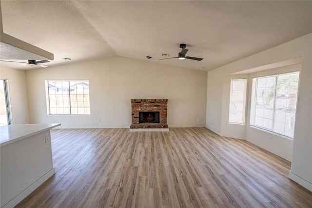 1925 E Ln Entrada Pl, Fort Mohave, AZ 86426 - unfurnished living room featuring ceiling fan, vaulted ceiling, light wood finished floors, and a fireplace