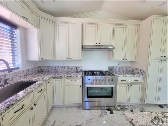 kitchen with marble finish floor, stainless steel range, a sink, light stone countertops, and under cabinet range hood