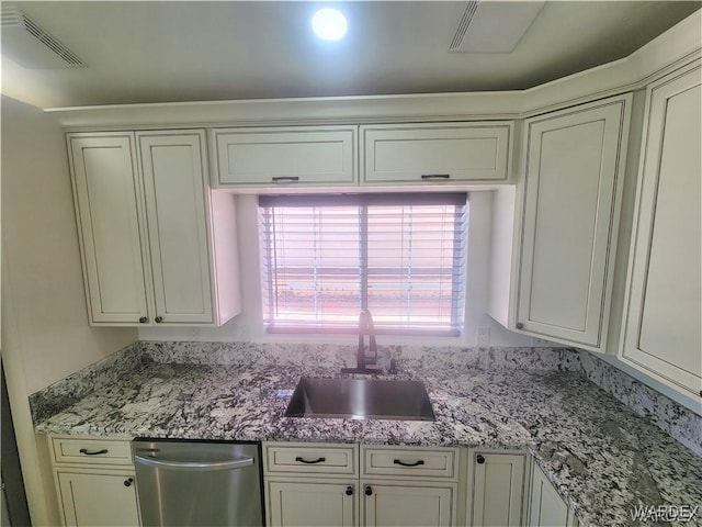 kitchen with light stone counters, a wealth of natural light, visible vents, and a sink