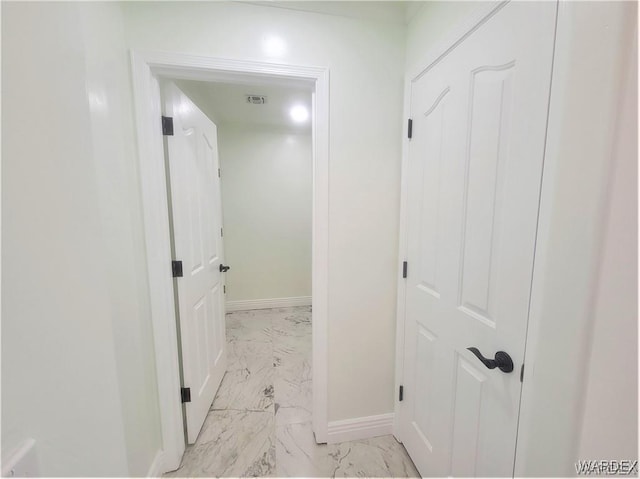 corridor featuring marble finish floor, visible vents, and baseboards