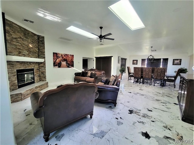 living room featuring a fireplace, a skylight, visible vents, a ceiling fan, and marble finish floor