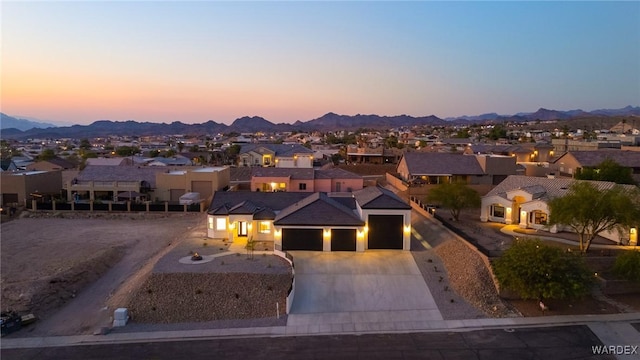 view of front of home featuring a garage, a residential view, a mountain view, and driveway