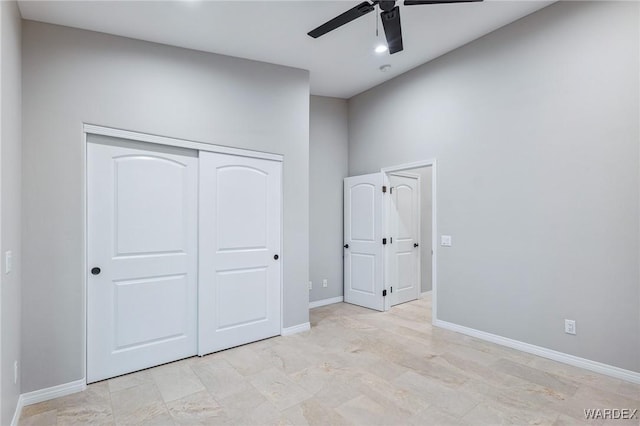 unfurnished bedroom featuring ceiling fan, baseboards, and a closet